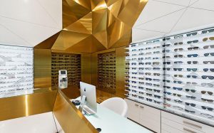 طراحی داخلی فروشگاه سام اپتیک با انتخاب متریال برنج خش دار طلایی